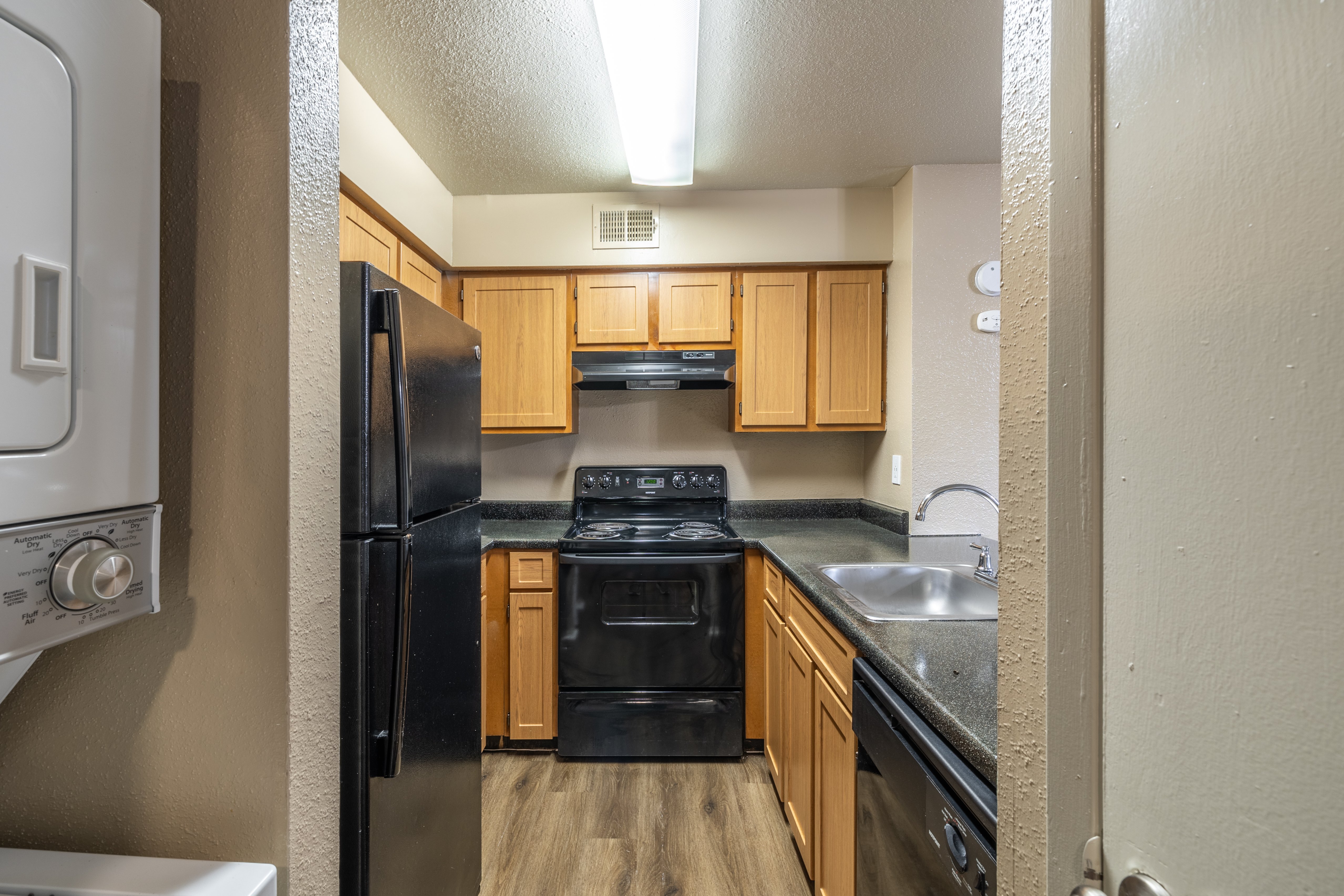 A kitchen with black appliances and wooden cabinets.